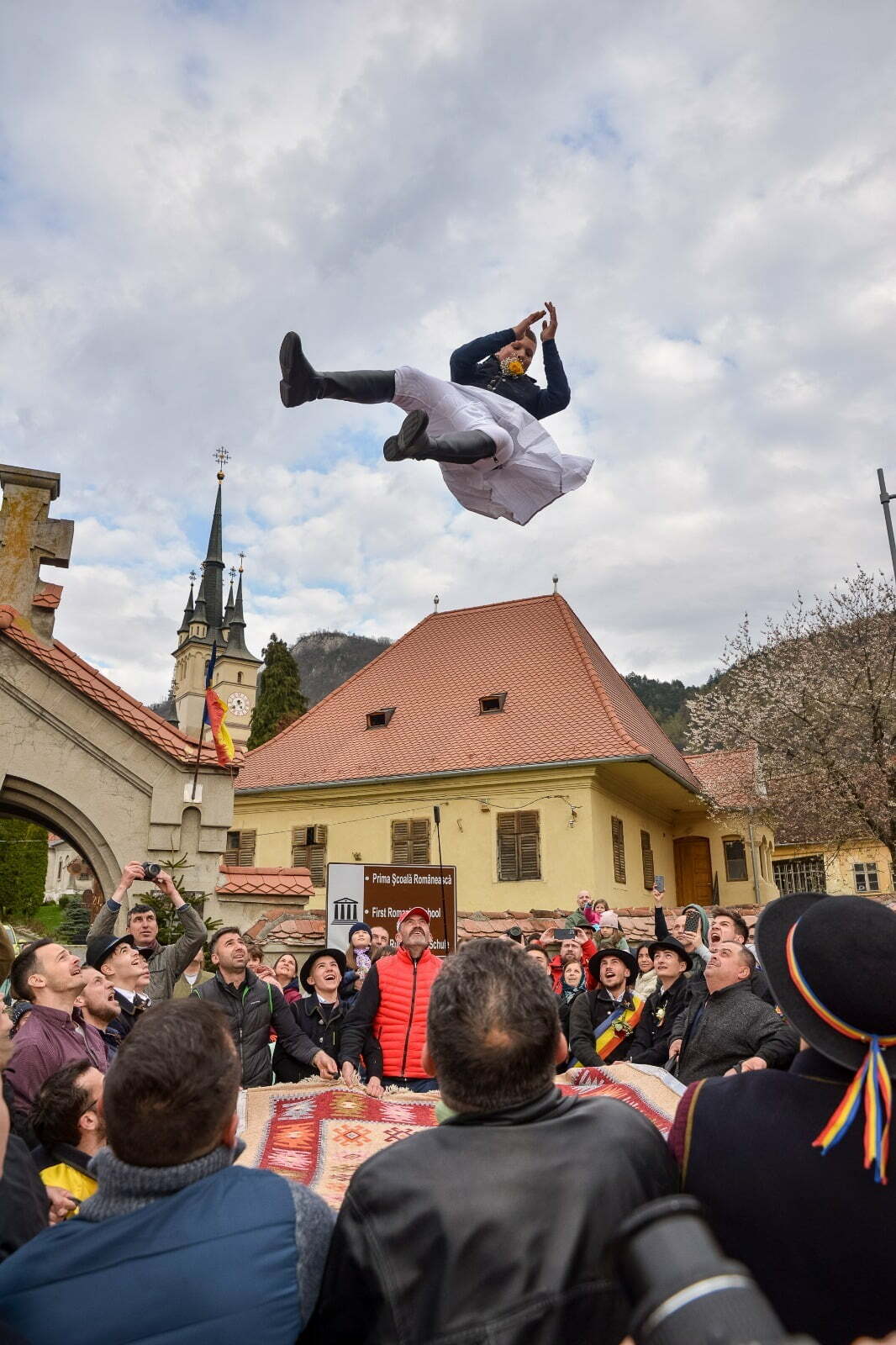 FOTO: Aruncatul în țol, unul dintre cele mai vechi și spectaculoase obiceiuri ale Junilor Tineri din Șchei, a adunat brașovenii în Piata Unirii